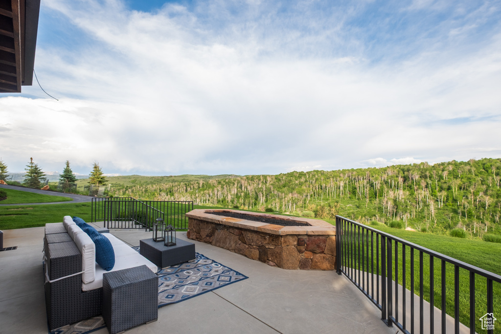 Patio / terrace featuring a wooded view and a yard