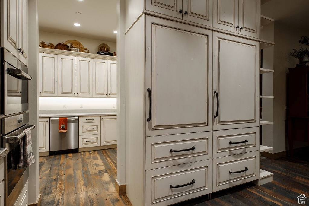 Kitchen with appliances with stainless steel finishes and dark hardwood / wood-style flooring