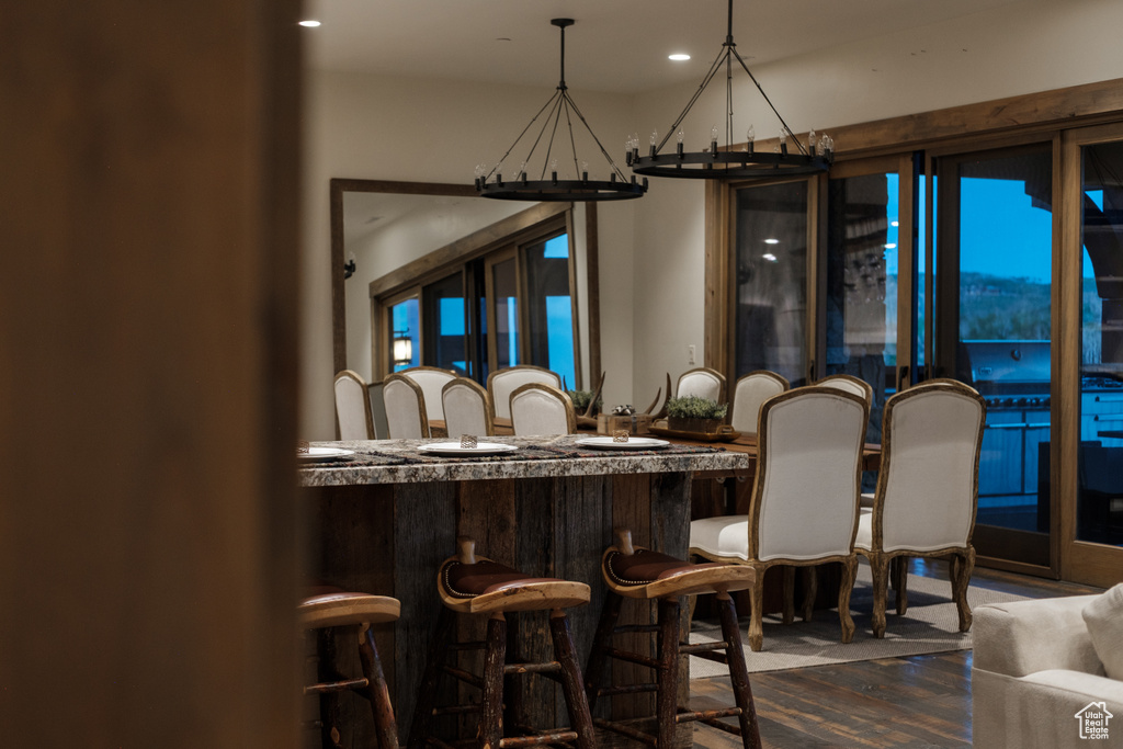 Dining area with a chandelier, dark wood-style flooring, and recessed lighting