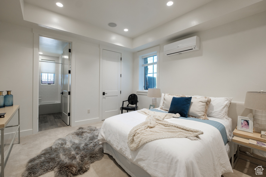 Bedroom featuring a wall mounted air conditioner, carpet, recessed lighting, and ensuite bathroom