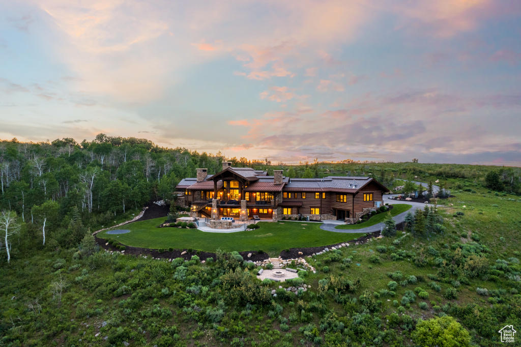 Rear view of house with a lawn, an outdoor fire pit, a chimney, a wooden deck, and a patio