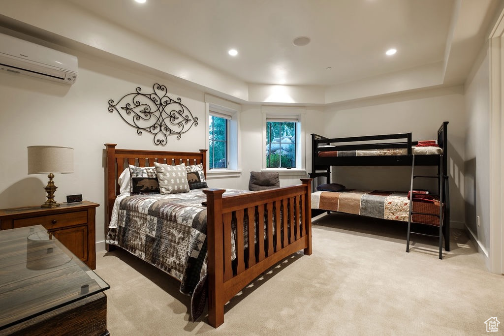 Bedroom with light colored carpet and a wall mounted air conditioner