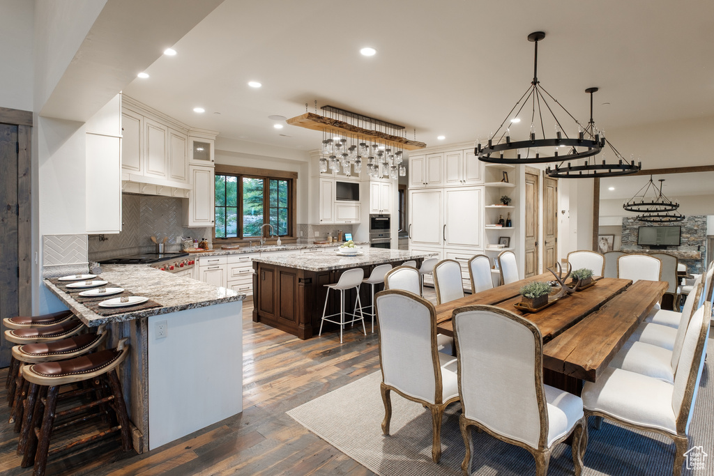 Dining area with a chandelier, recessed lighting, and dark wood-style floors