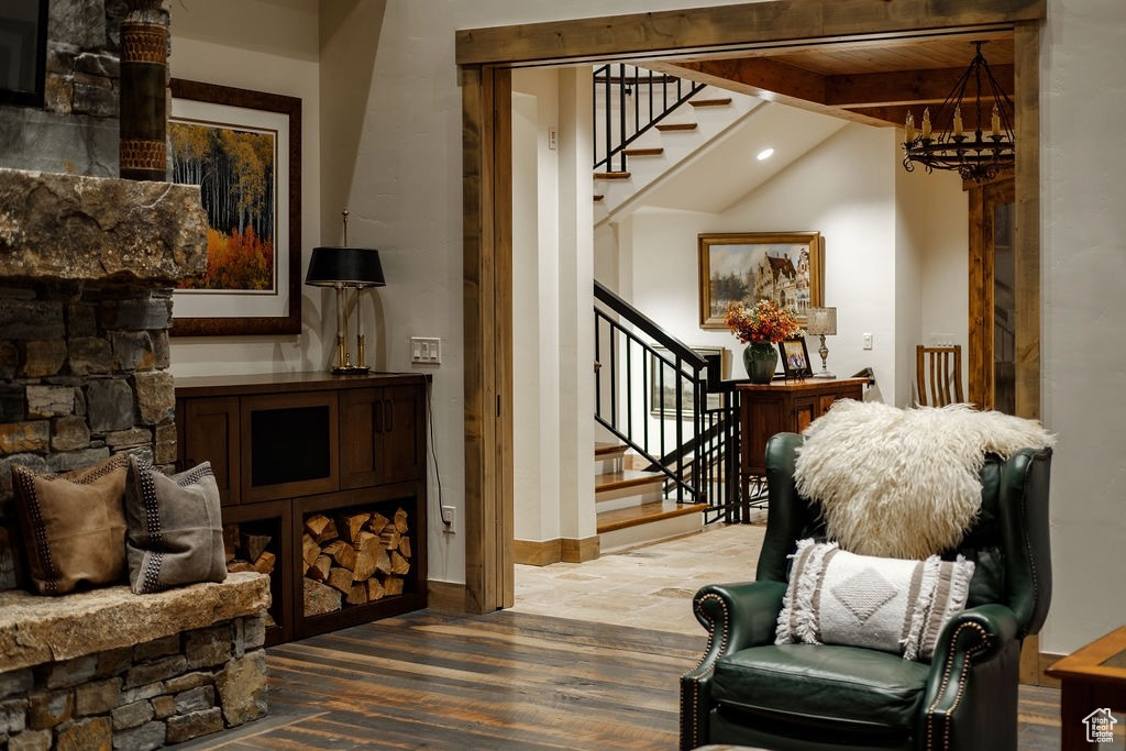 Living area featuring a notable chandelier, lofted ceiling with beams, and hardwood / wood-style floors