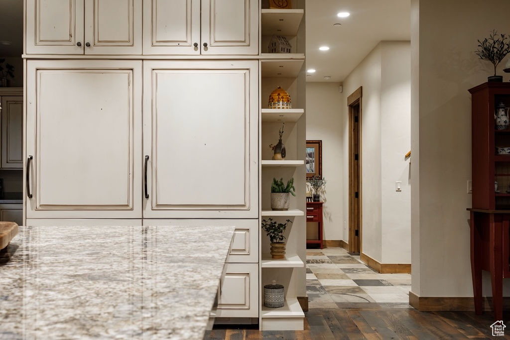 Kitchen with cream cabinetry and hardwood / wood-style flooring