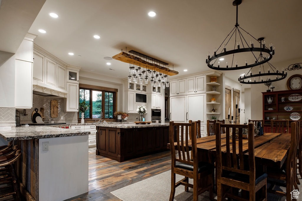 Dining area with a chandelier and wood-type flooring