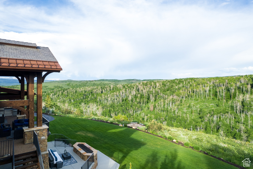 View of grassy yard with a view of trees