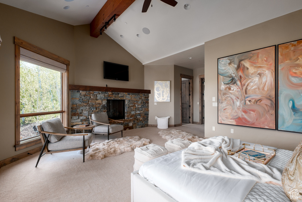 Living room with ceiling fan, carpet floors, and a stone fireplace