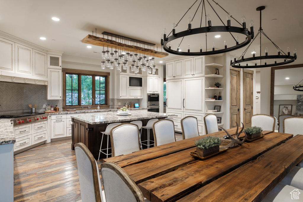 Dining area featuring a chandelier, recessed lighting, and light wood-style flooring