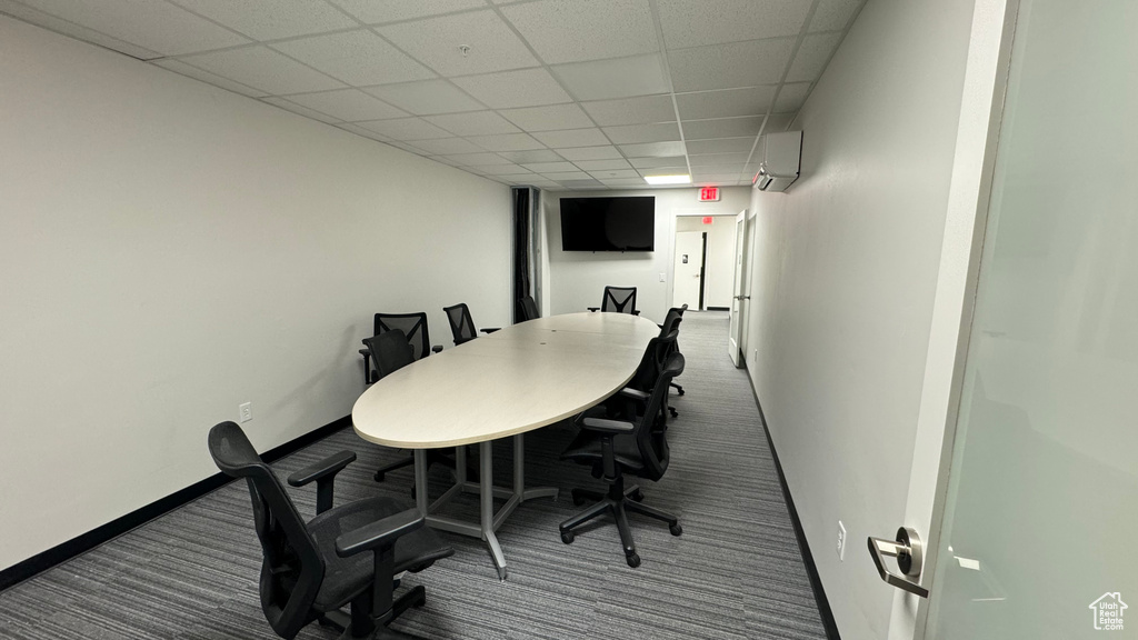 Carpeted office space with a drop ceiling and a wall unit AC