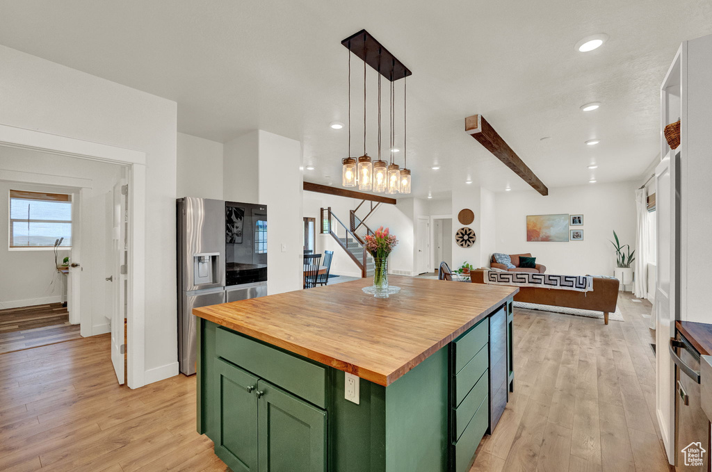 Kitchen with a center island, light wood-type flooring, stainless steel fridge, wood counters, and green cabinetry