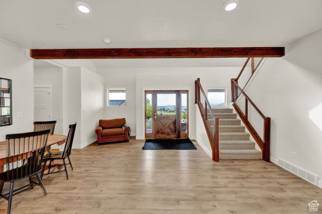 Entrance foyer featuring beamed ceiling and light wood-type flooring