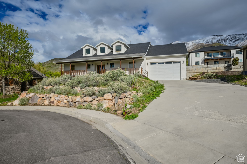 View of front of home with a mountain view, a garage, and a porch