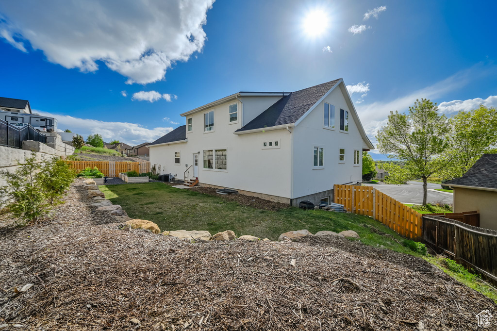 Back of property with a lawn