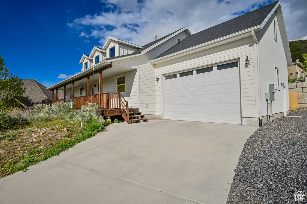 View of front of house featuring a garage and covered porch