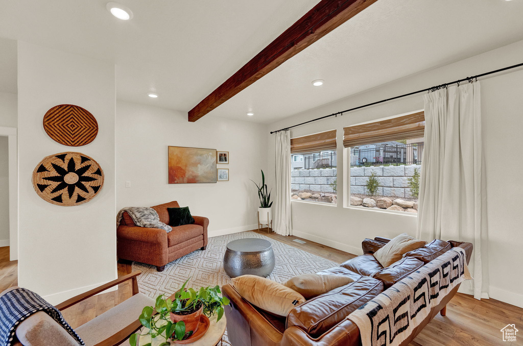 Living room featuring beamed ceiling and light wood-type flooring