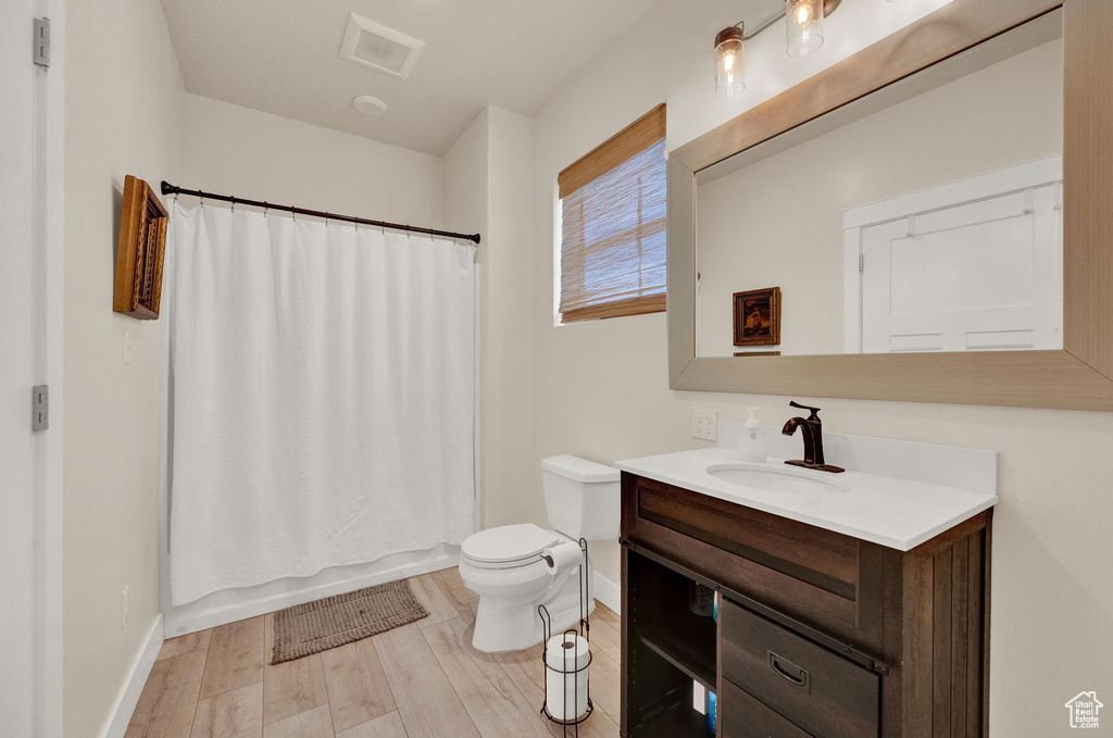 Bathroom with hardwood / wood-style floors, vanity, and toilet