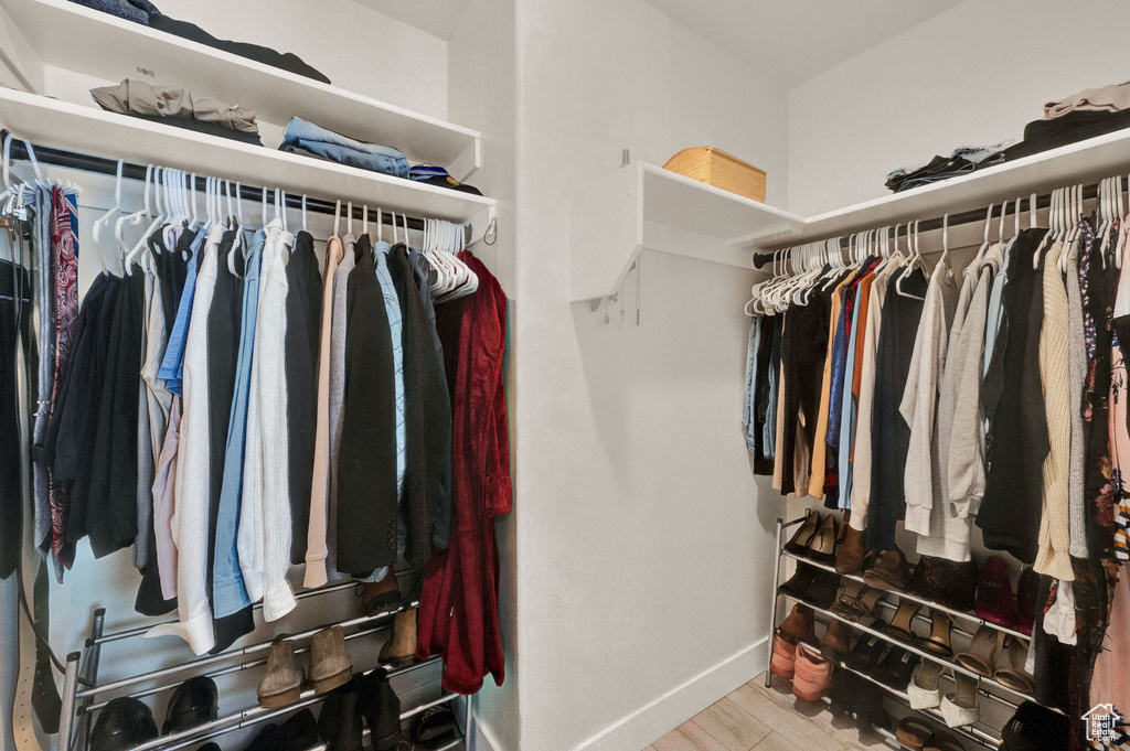 Spacious closet with light hardwood / wood-style flooring