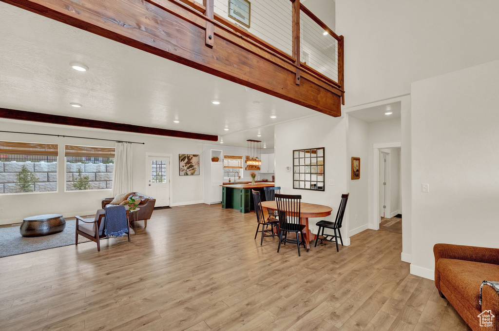 Dining space featuring light hardwood / wood-style flooring and a towering ceiling