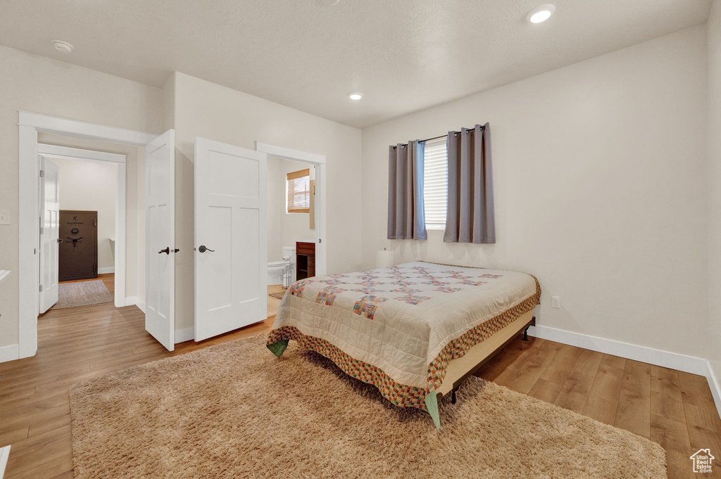 Bedroom with hardwood / wood-style flooring and ensuite bathroom