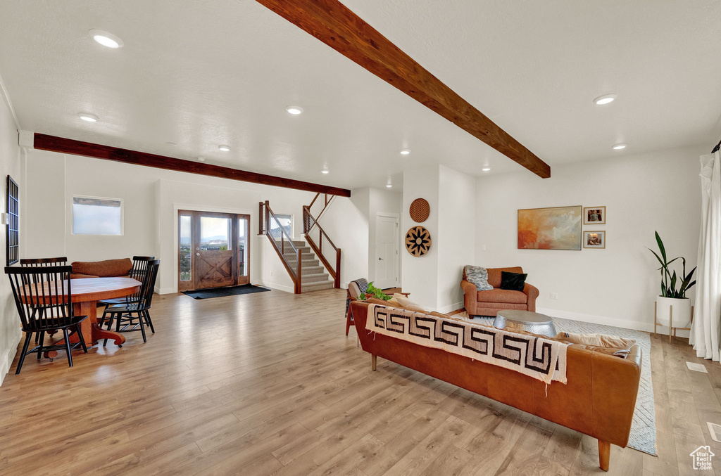 Living room with beamed ceiling and light hardwood / wood-style floors