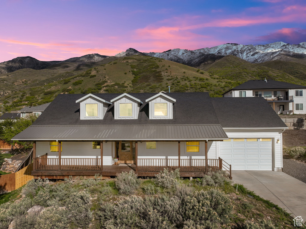 View of front facade featuring a mountain view, a garage, and a porch