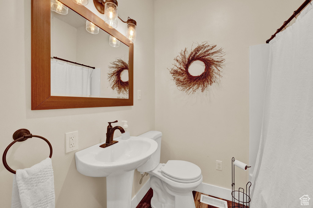 Bathroom with hardwood / wood-style floors and toilet