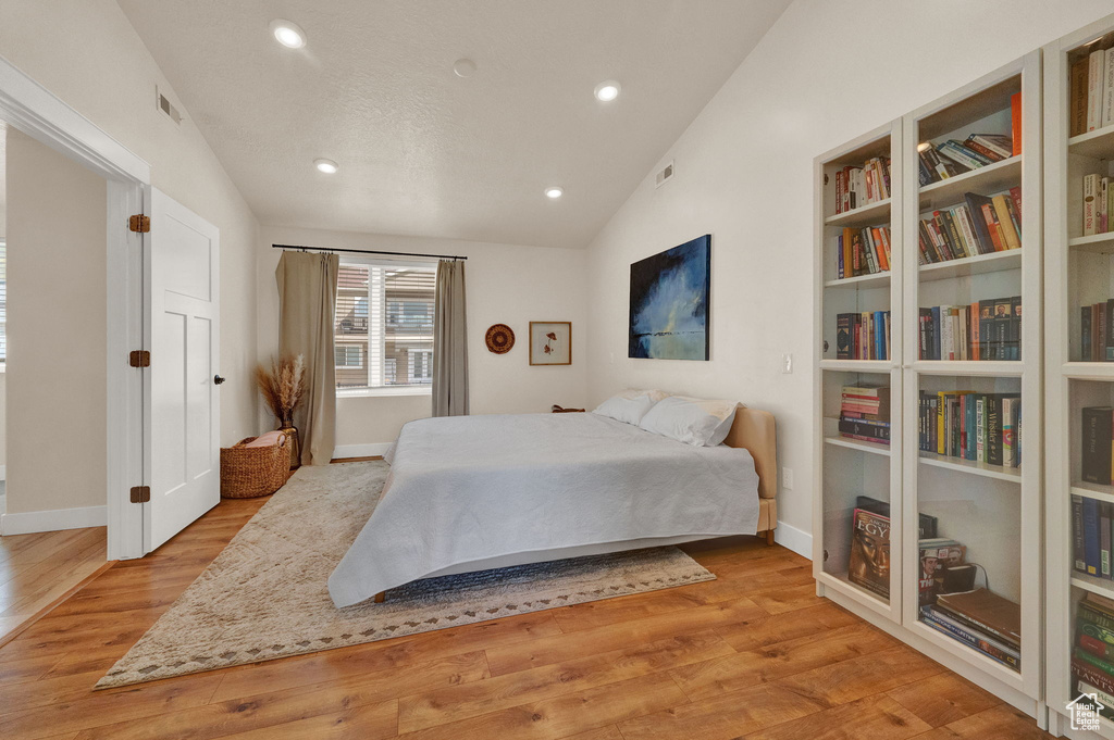 Bedroom featuring light hardwood / wood-style flooring and vaulted ceiling