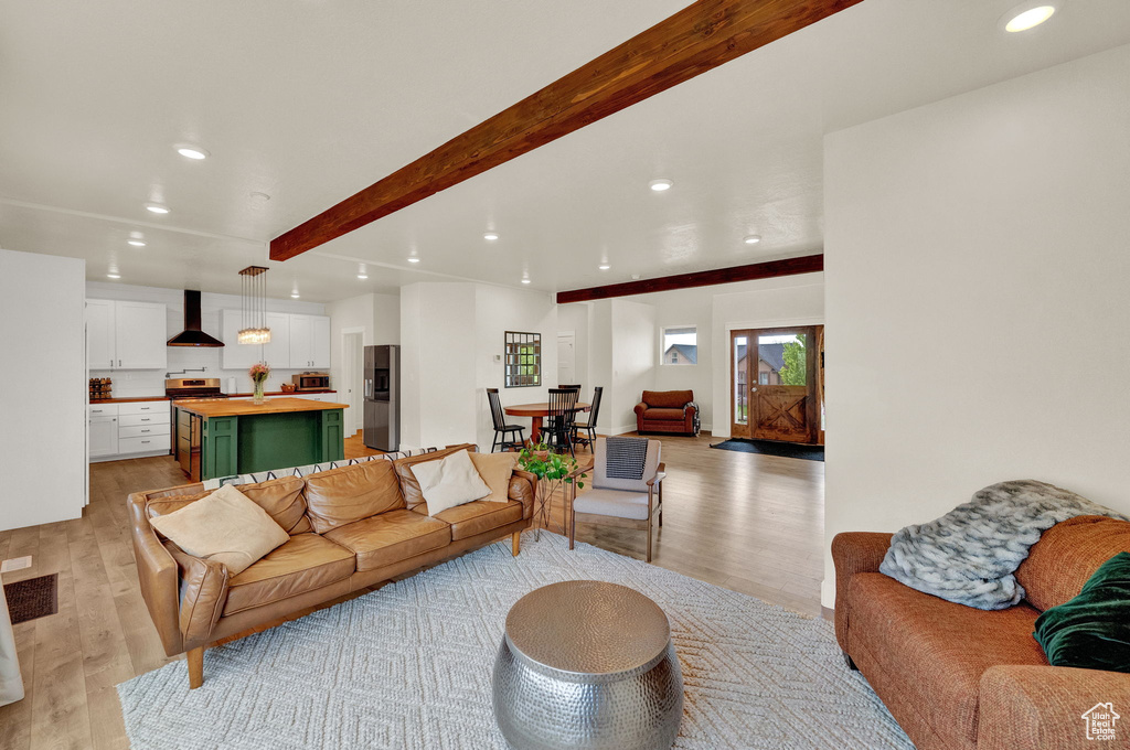 Living room with beamed ceiling and light hardwood / wood-style floors