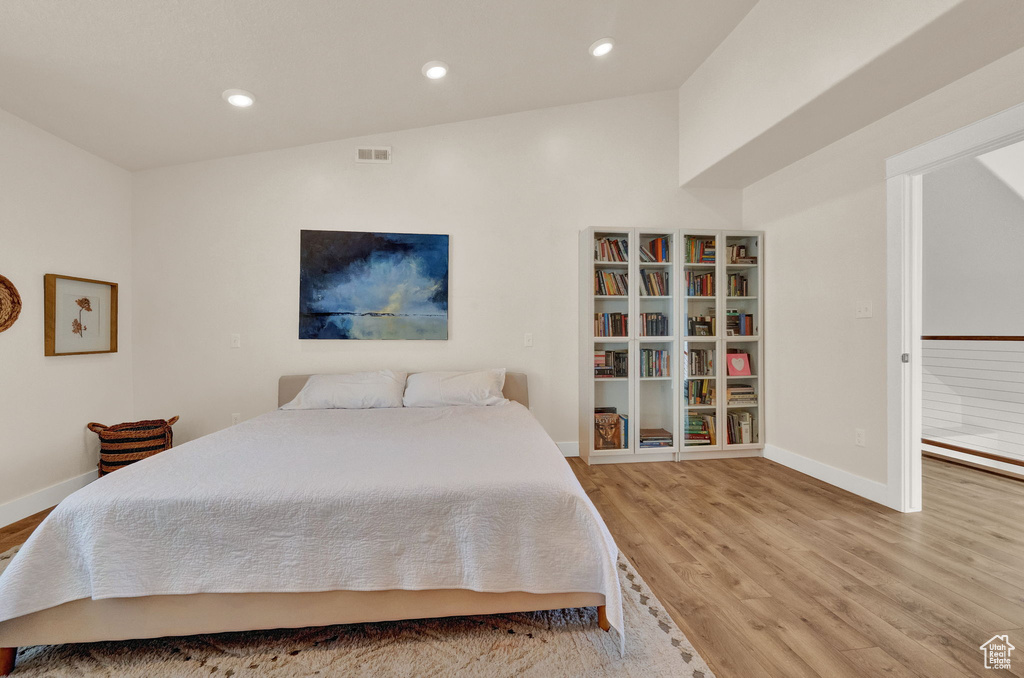 Bedroom featuring lofted ceiling and hardwood / wood-style flooring