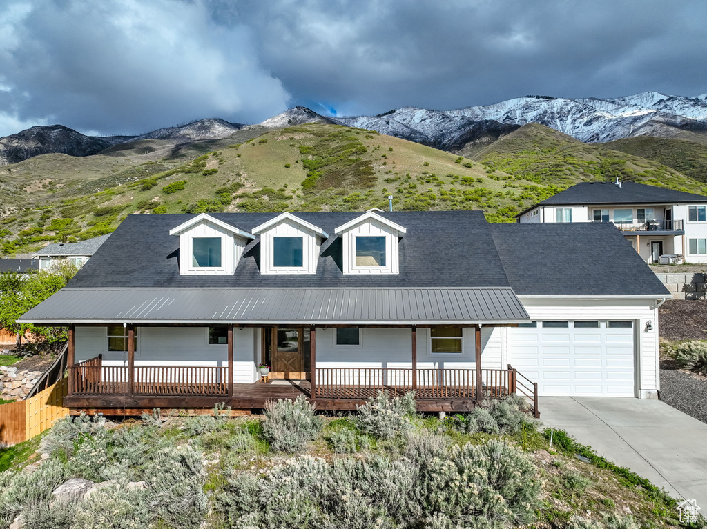 View of front of house featuring a mountain view, a garage, and a porch