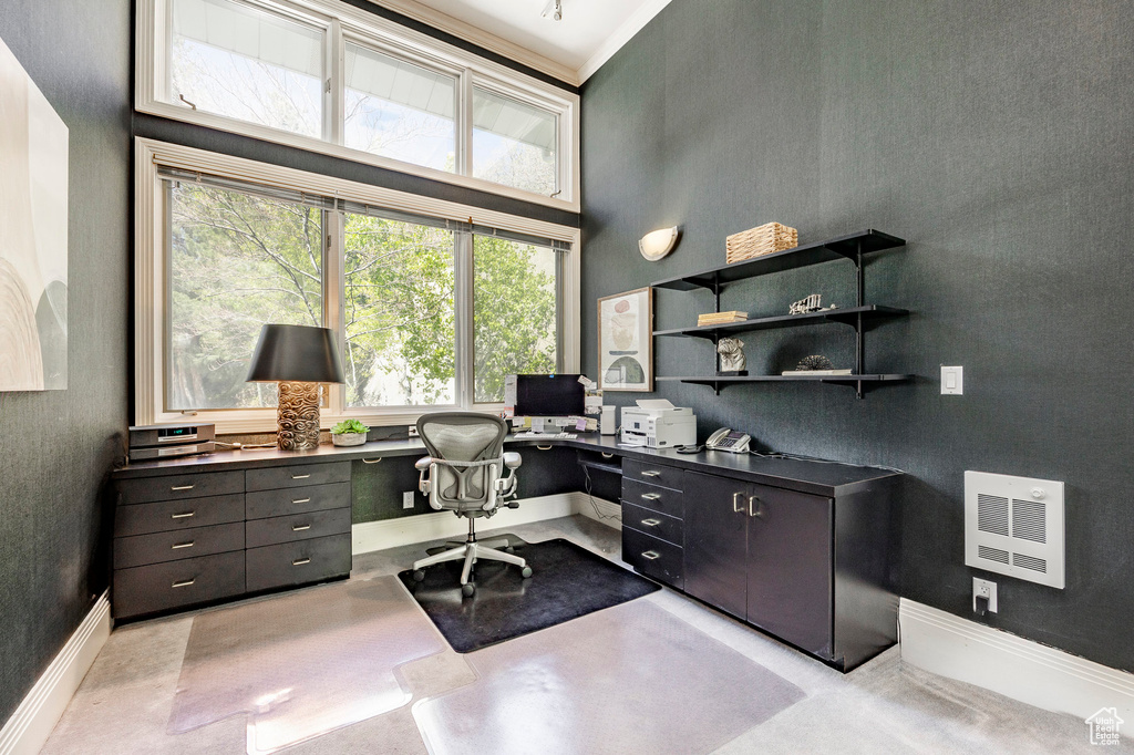 Office space featuring a towering ceiling and built in desk