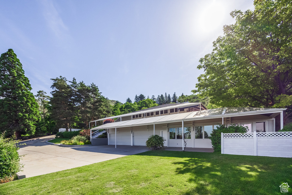 View of front facade with a carport and a front lawn