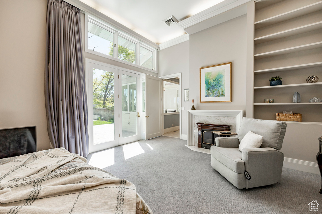 Carpeted bedroom featuring a towering ceiling, ornamental molding, french doors, and access to exterior