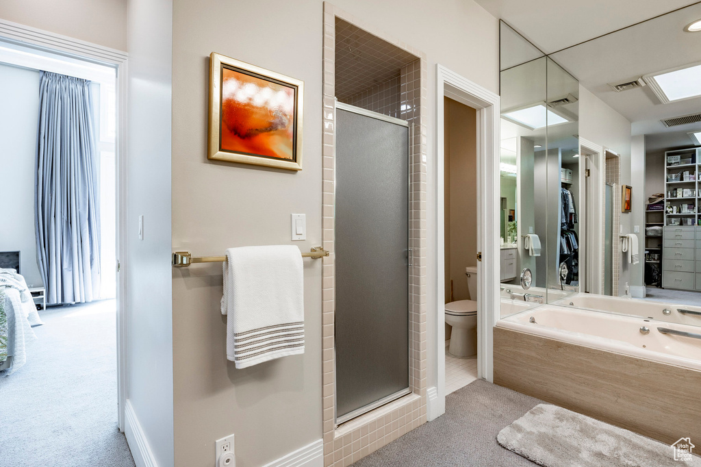 Bathroom featuring a shower with shower door and toilet