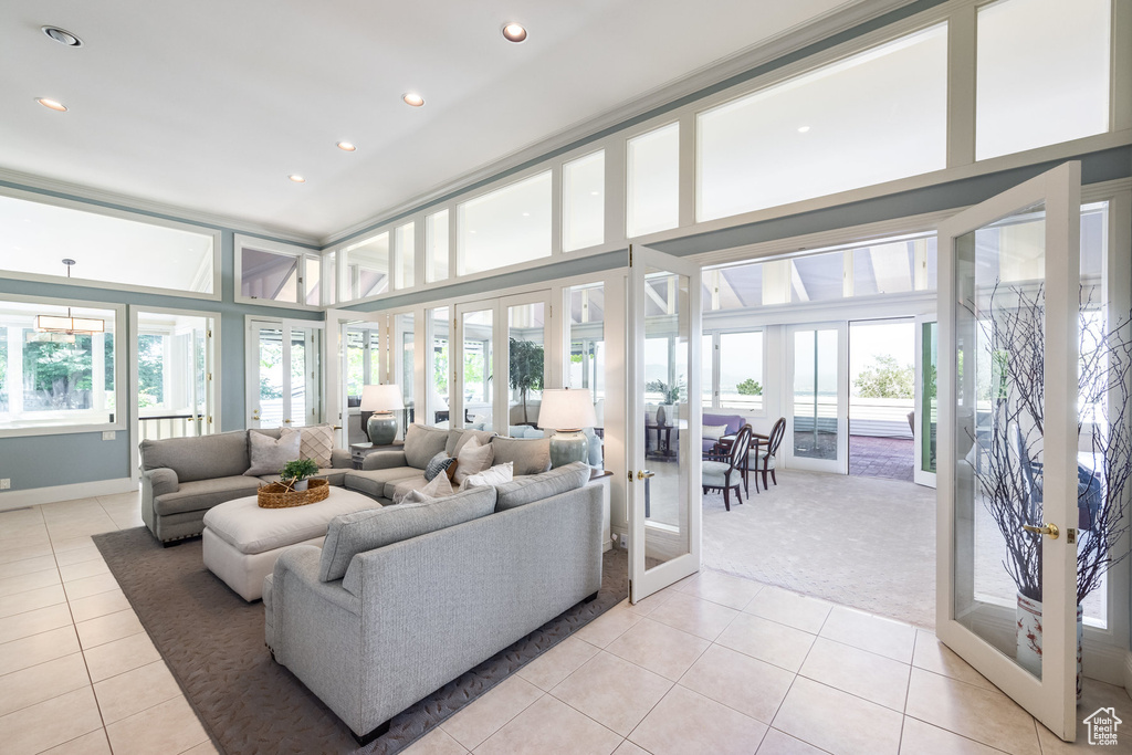 Tiled living room with a wealth of natural light, a towering ceiling, and french doors