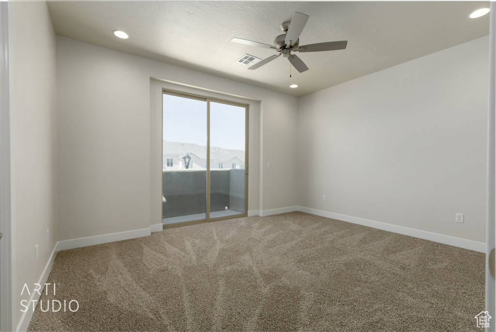 Carpeted empty room featuring ceiling fan