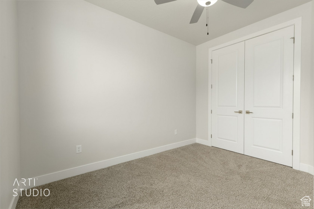 Unfurnished bedroom featuring a closet, carpet floors, and ceiling fan