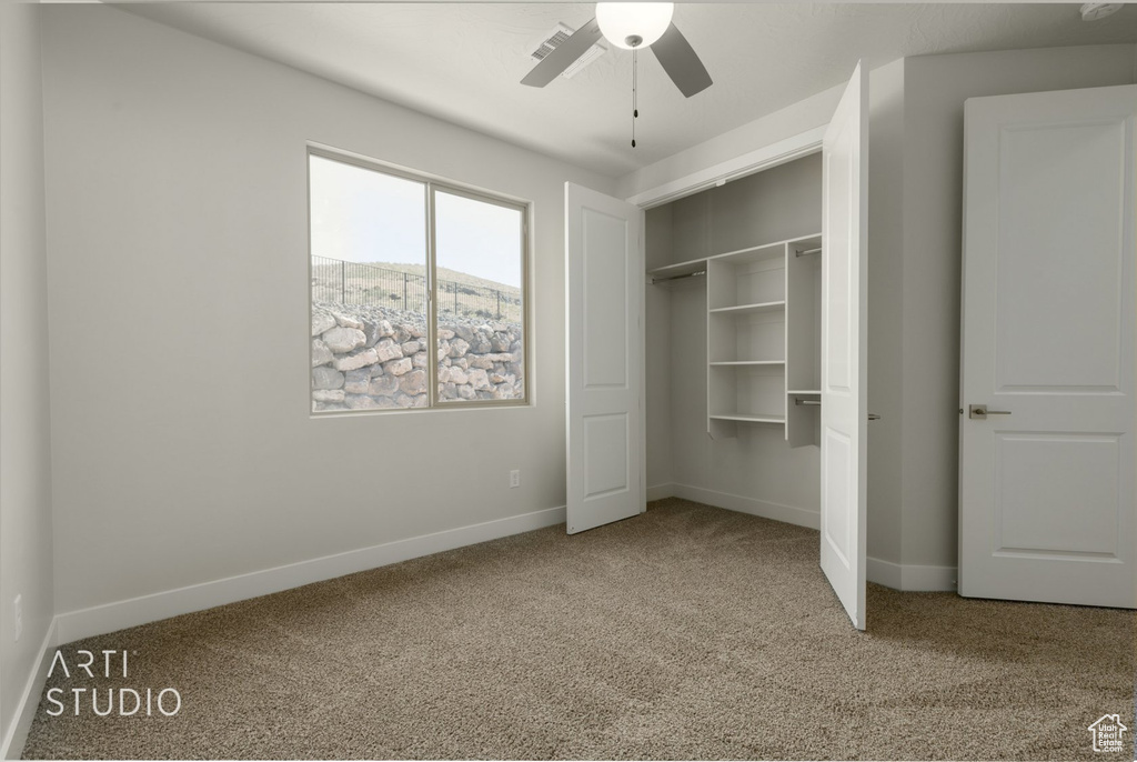 Unfurnished bedroom with a closet, ceiling fan, and carpet floors