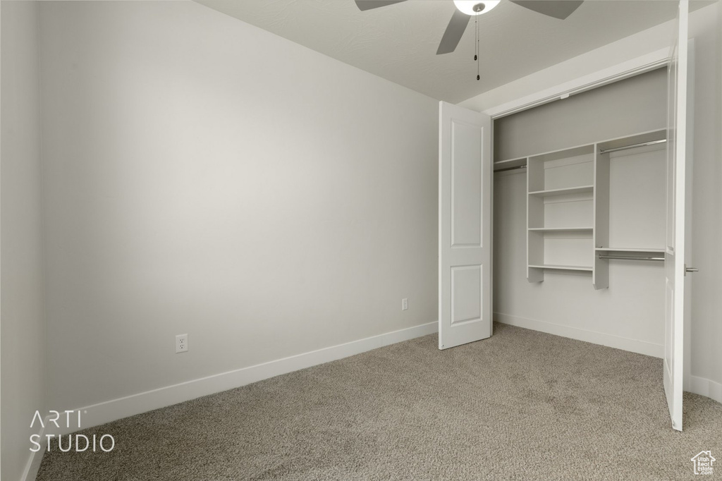 Unfurnished bedroom featuring carpet flooring, a closet, and ceiling fan