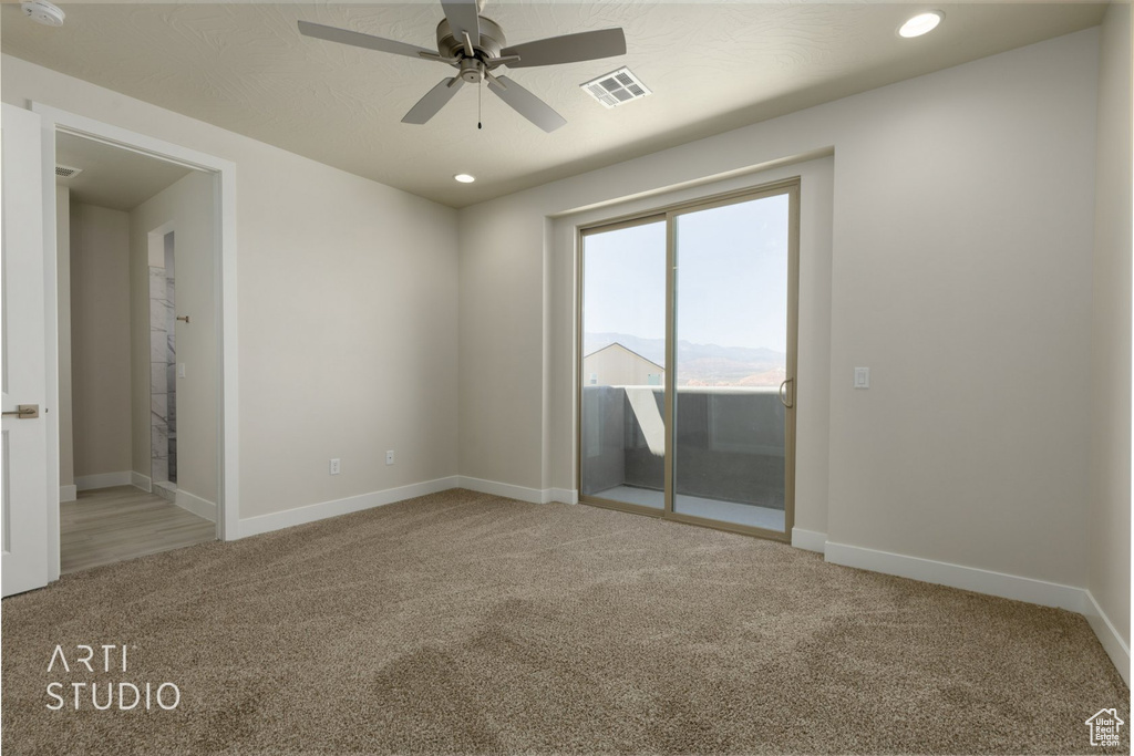 Unfurnished room featuring carpet floors and ceiling fan