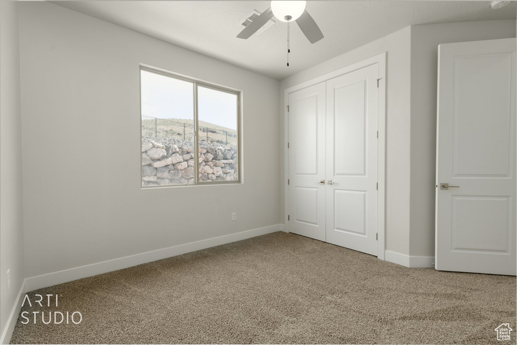 Unfurnished bedroom with a closet, ceiling fan, and carpet flooring