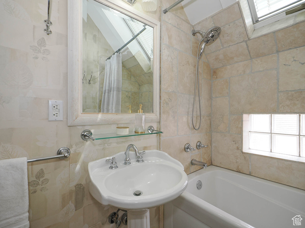 Bathroom with a skylight, shower / tub combo, and sink