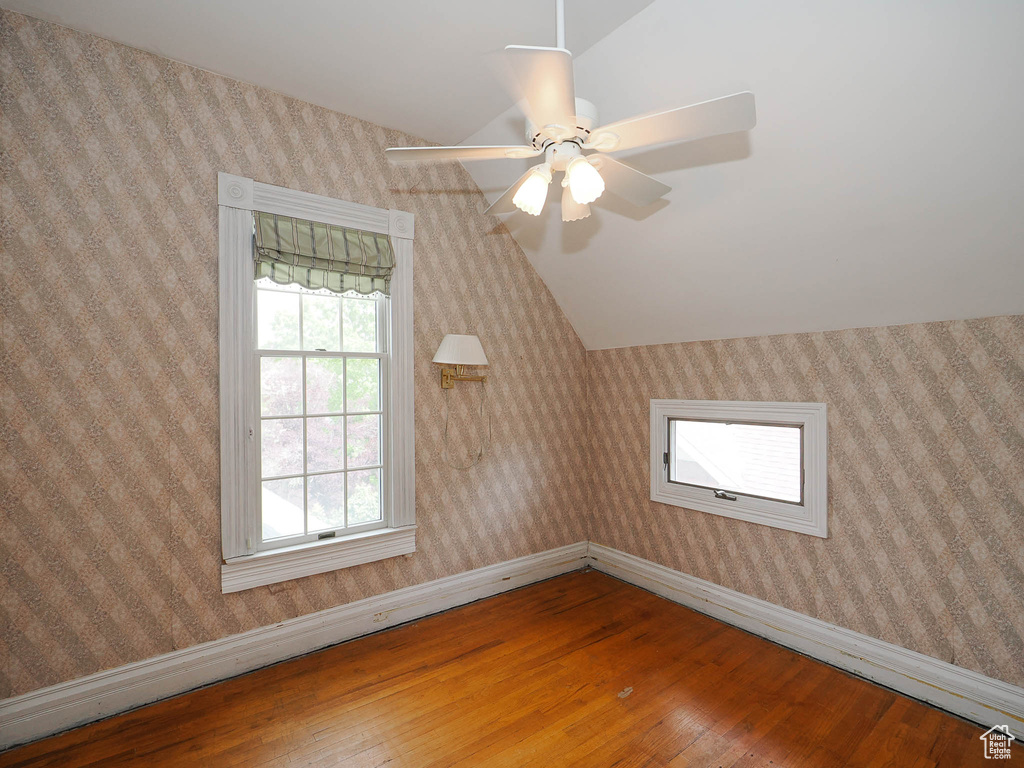 Additional living space with ceiling fan, hardwood / wood-style floors, and vaulted ceiling