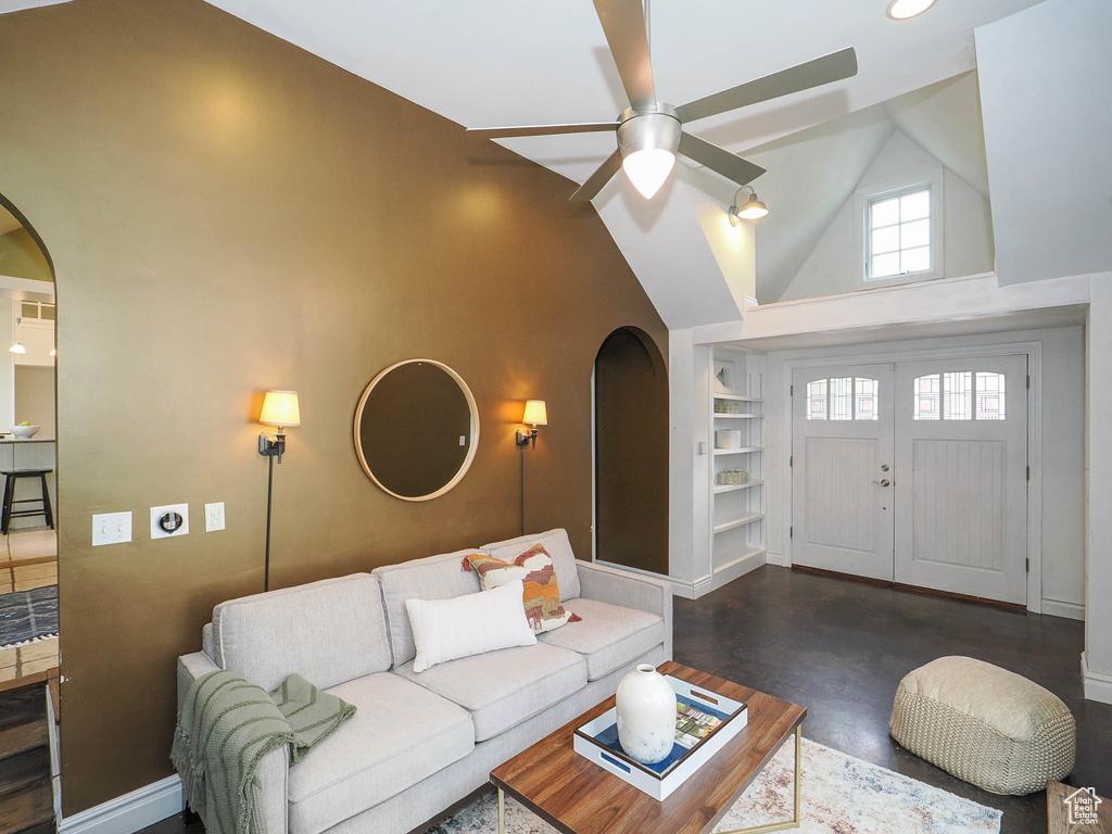 Living room with ceiling fan and high vaulted ceiling