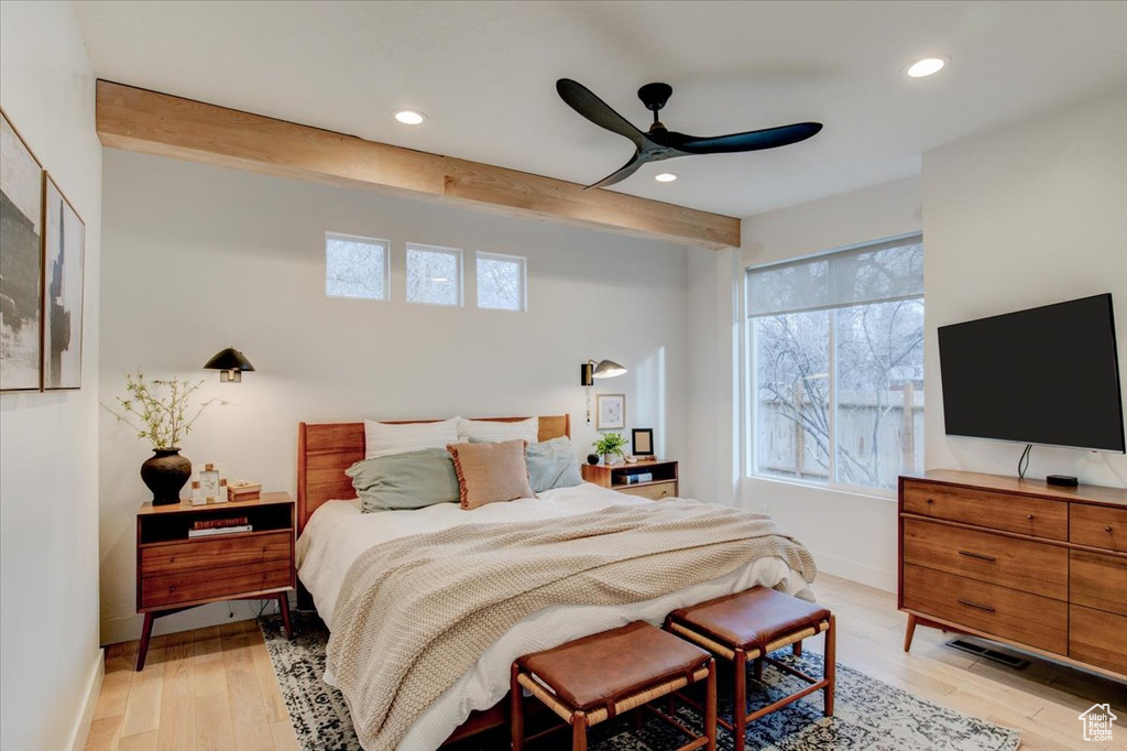Bedroom featuring ceiling fan, beamed ceiling, and light wood-type flooring