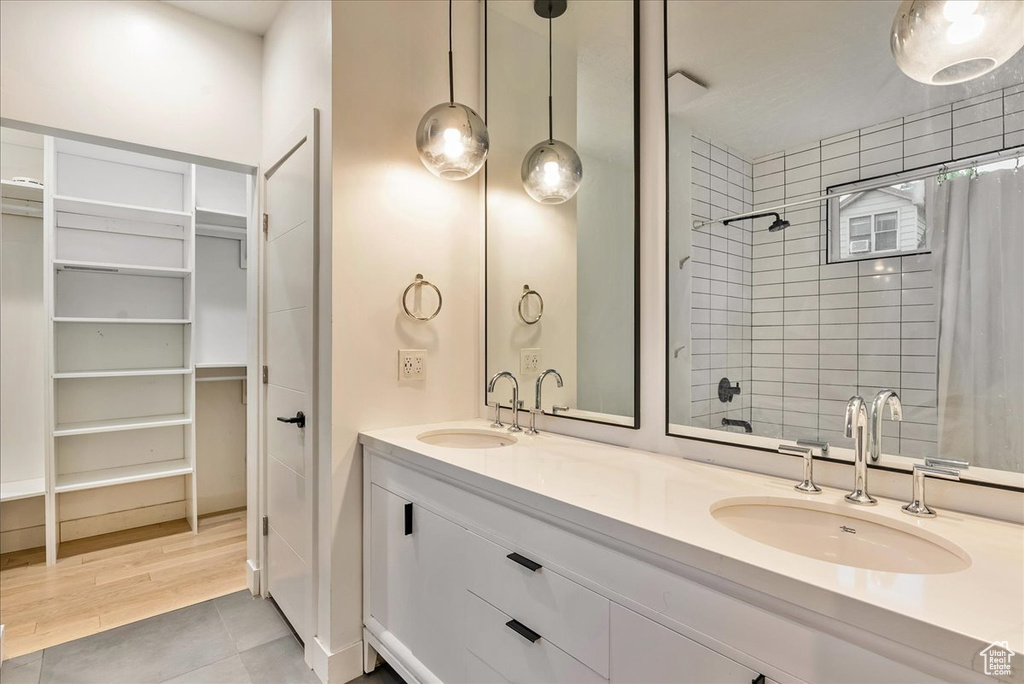 Bathroom with dual sinks, tile floors, and large vanity