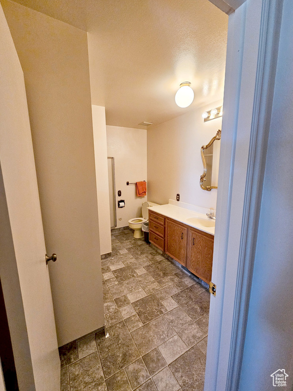 Bathroom featuring tile flooring, vanity, and toilet