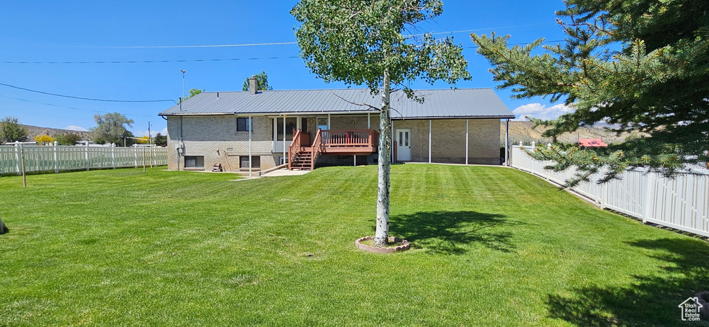 Back of house featuring stairs, a wooden deck, metal roof, and a sunroom