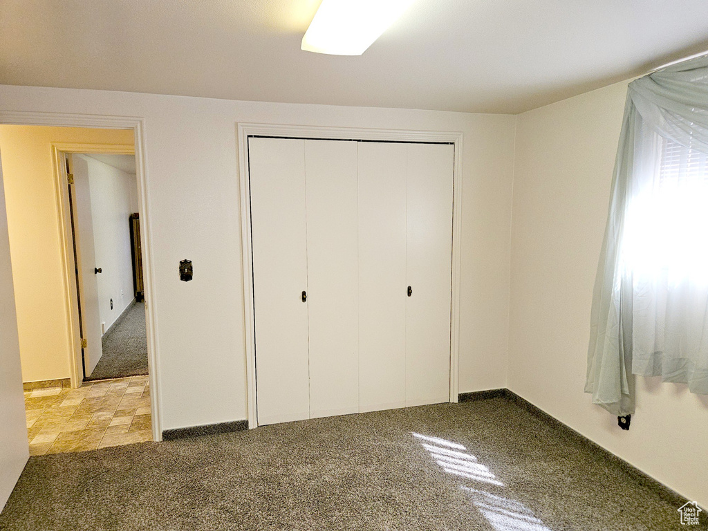 Unfurnished bedroom with tile flooring and a closet